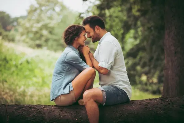 صورة تحتوي على شاب وفتاة يجلسان على جذع شجرة جلب الحبيب غصب عنه 